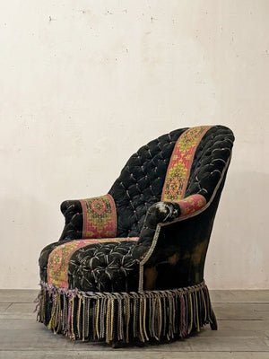 Black velvet buttoned armchair