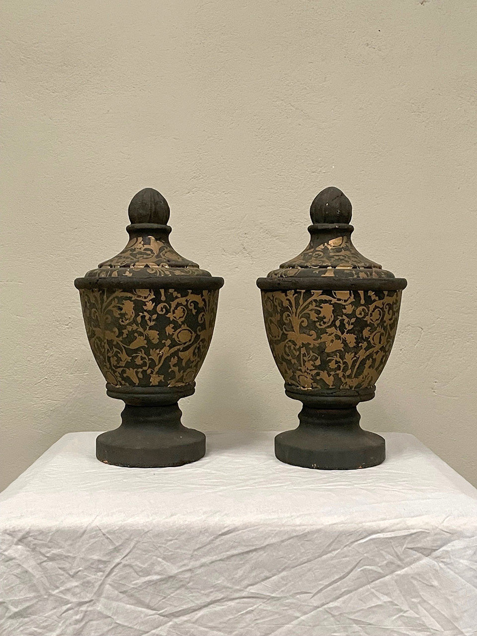 Pair of black and gold painted terracotta urns