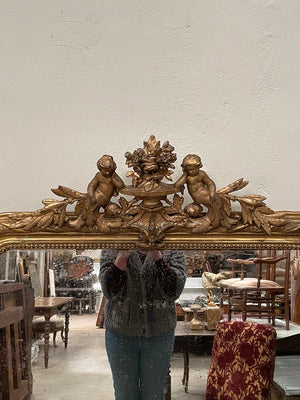 Tall gilded mirror with cherub crest