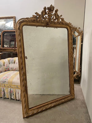 Tall gilded mirror with cherub crest