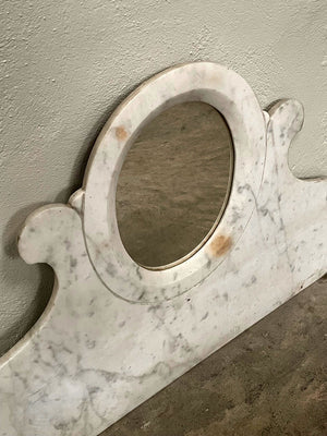 Oval mirror set in marble