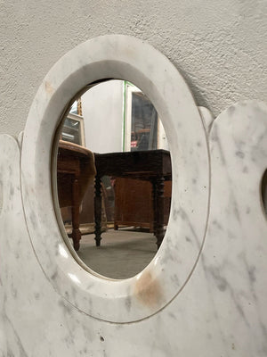 Oval mirror set in marble