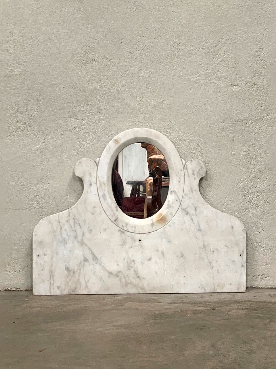 Oval mirror set in marble