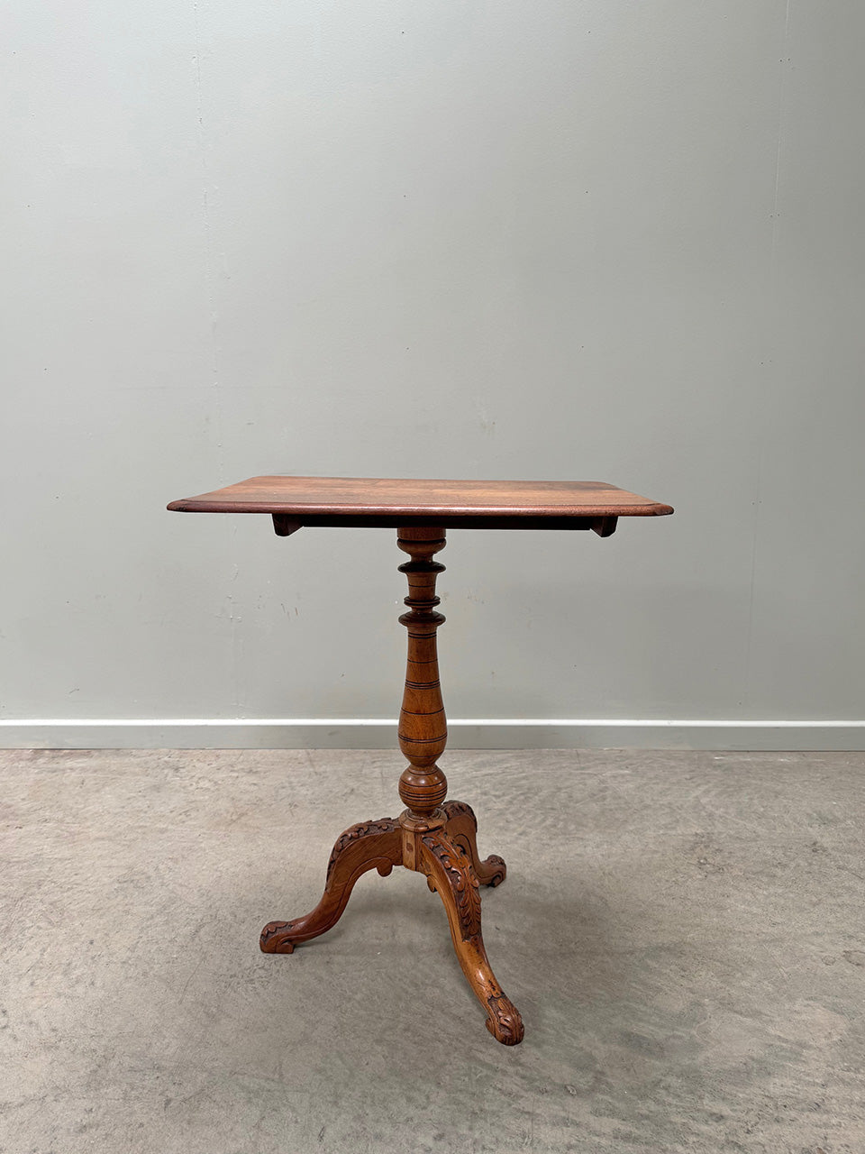 Tilt top table with carved base