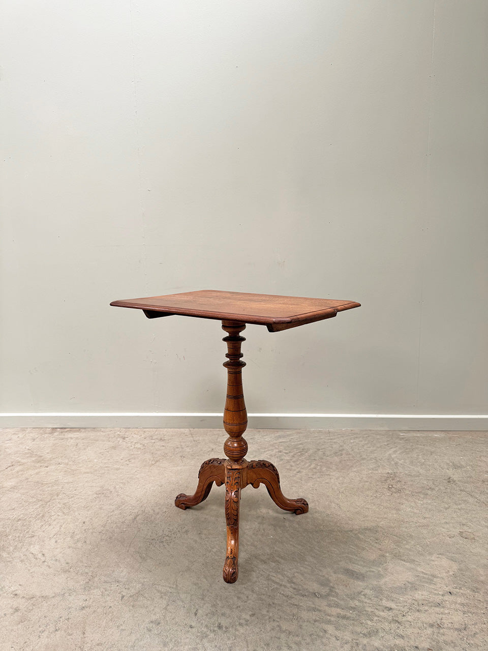 Tilt top table with carved base